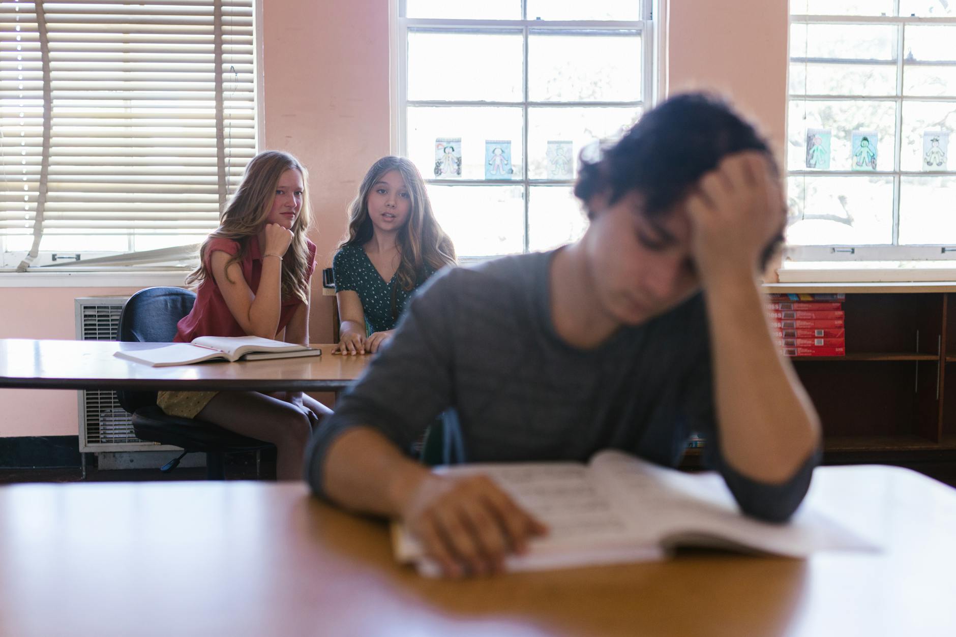 two women bullying a man in the school